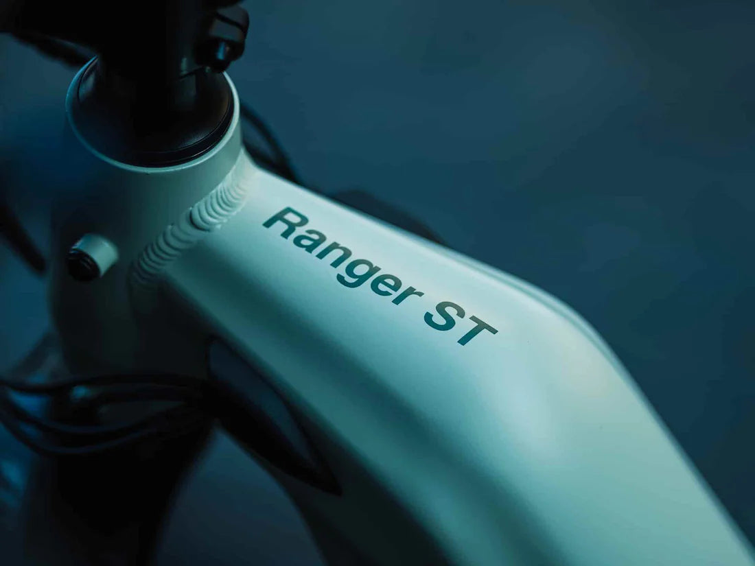Velowave Ranger Step-Thru 3.0 Torque Sensor Electric Bike Close-up of a bike frame with 'Ranger ST' branding on a dark background. Valowave Ranger Step-Thru 3.0 Torque Sensor Electric Bike