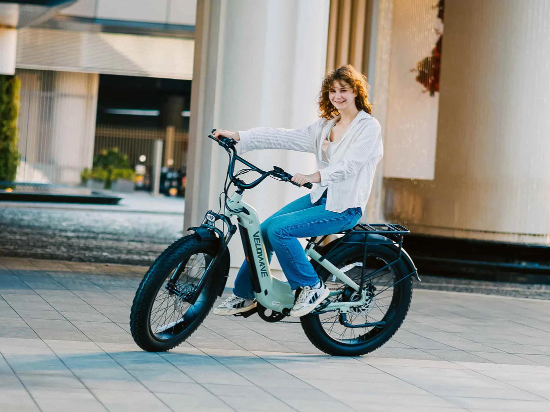 Velowave Ranger Step-Thru 3.0 Torque Sensor Electric Bike Woman sitting on an electric bike in an urban setting. Valowave Ranger Step-Thru 3.0 Torque Sensor Electric Bike