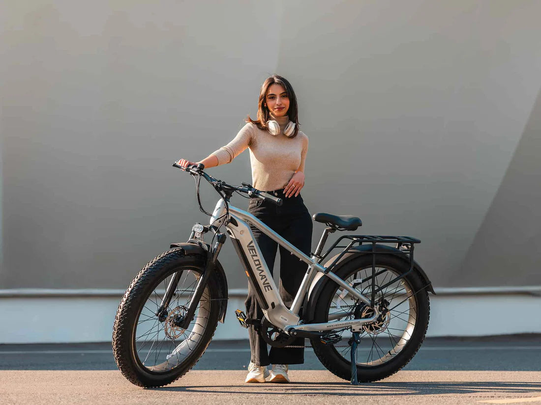 Velowave Ranger 3.0 Fat Tire All-Terrain Electric Bike Woman standing next to an electric bike against a plain background. Valowave Ranger 3.0 Fat Tire All-Terrain Electric Bike