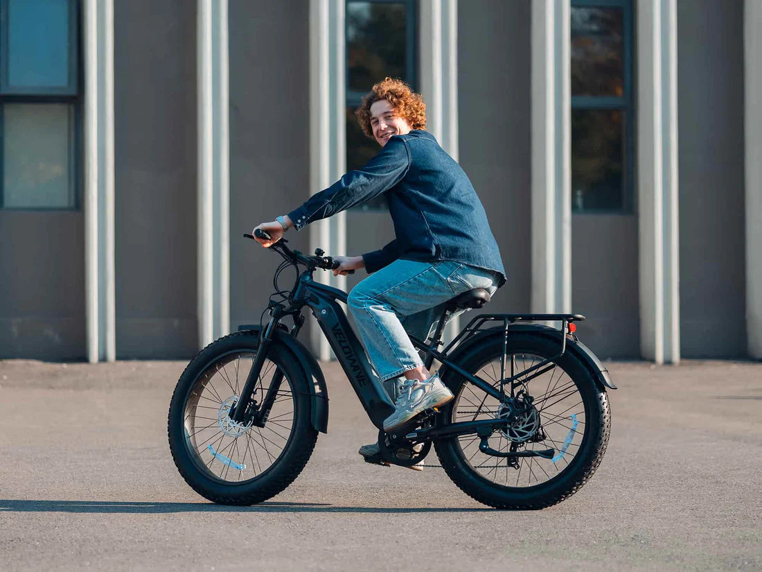 Velowave Ranger 3.0 Fat Tire All-Terrain Electric Bike Person riding an electric bike on a paved surface with a building in the background. Valowave Ranger 3.0 Fat Tire All-Terrain Electric Bike