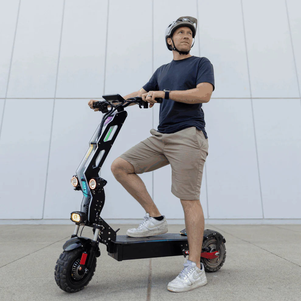 Freego D11 Landtiger Electric Scooter Foldable Dual Motor 4000W Man riding an electric scooter against a white wall. Freego D11 Landtiger Electric Scooter Foldable Dual Motor 4000W