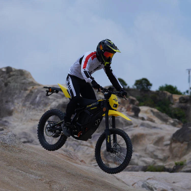 Freego Nova 5 Mid-Drive Off-Road Electric Dirt Bike Person riding a yellow dirt bike on rocky terrain.Freego Nova 5 Mid-Drive Off-Road Electric Dirt Bike