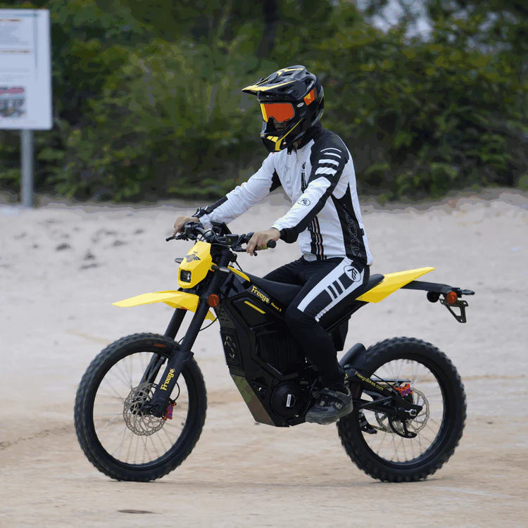 Freego Nova 5 Mid-Drive Off-Road Electric Dirt Bike Person riding a yellow and black electric bike on a sandy surface with greenery in the background.Freego Nova 5 Mid-Drive Off-Road Electric Dirt Bike