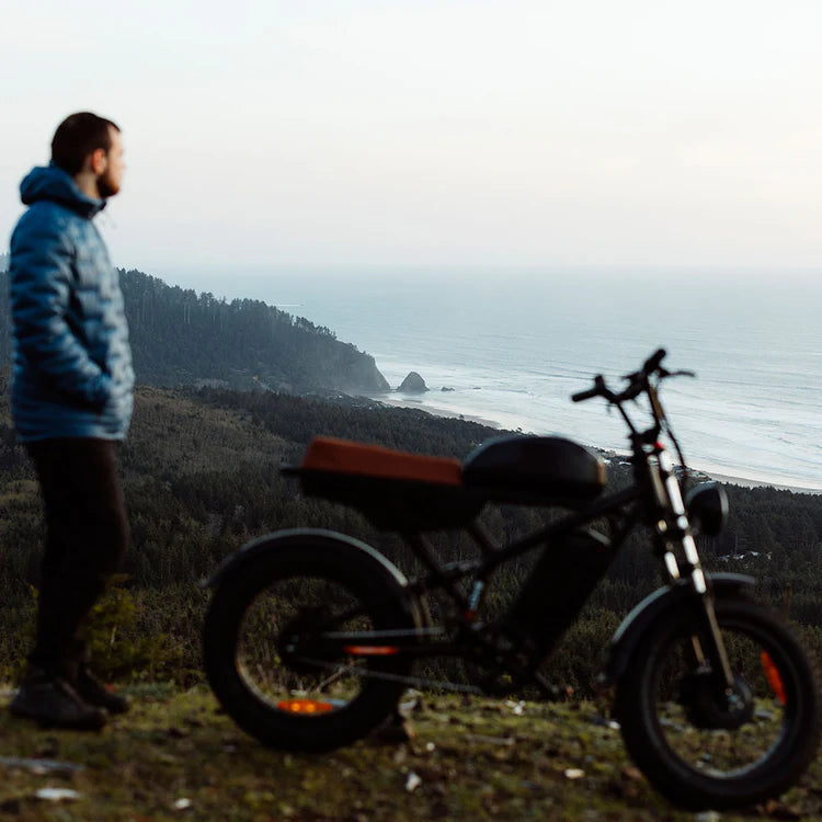Freego Flash F3 Pro Max Dual Motor and Battery eBike Man standing next to a motorcycle overlooking a coastal landscape. Freego Flash F3 Pro Max Dual Motor and Battery eBike