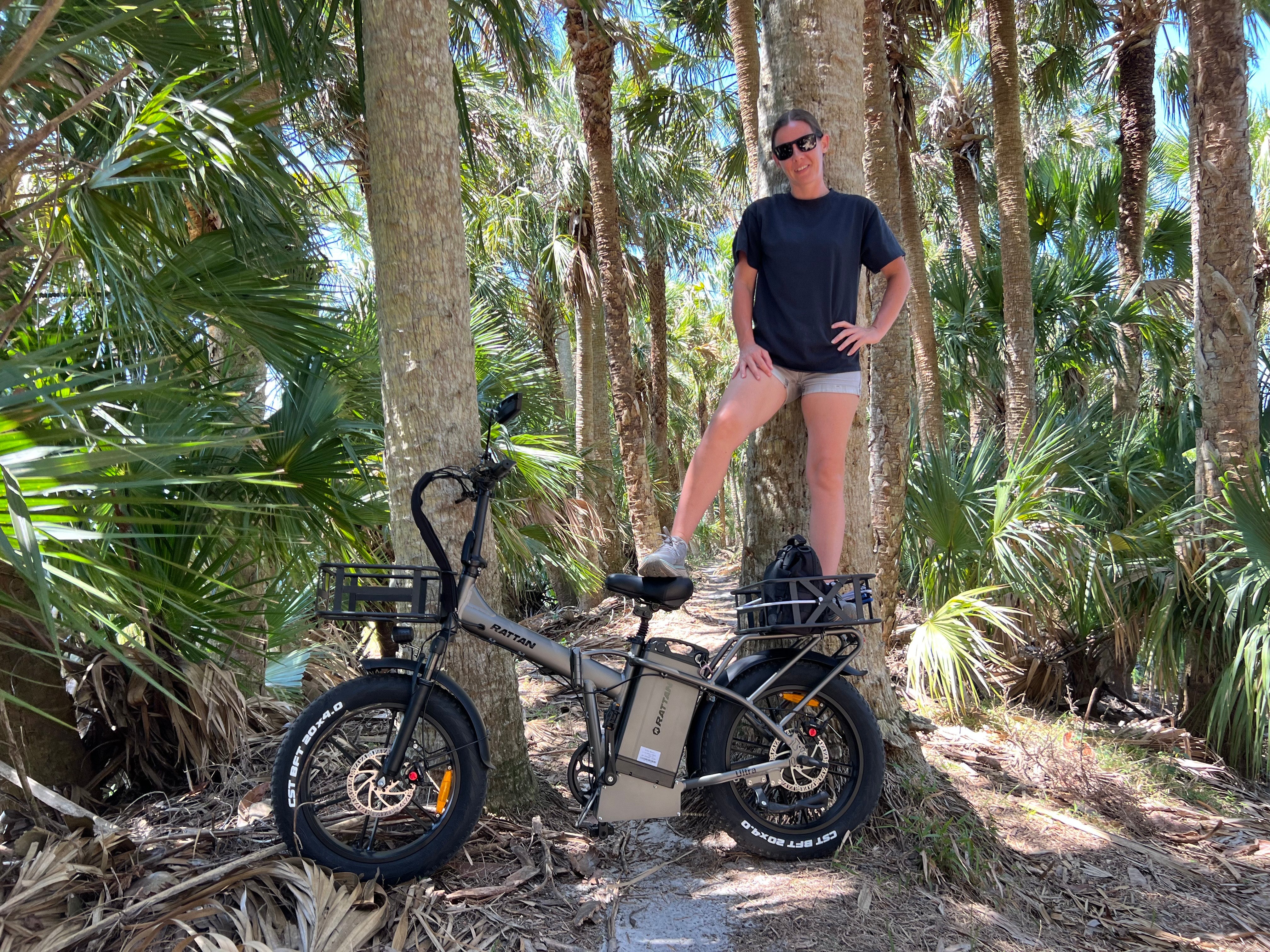 Rattan LM Ultra Folding ebike Person standing next to an electric bike in a forest setting. Rattan LM Ultra Folding ebike