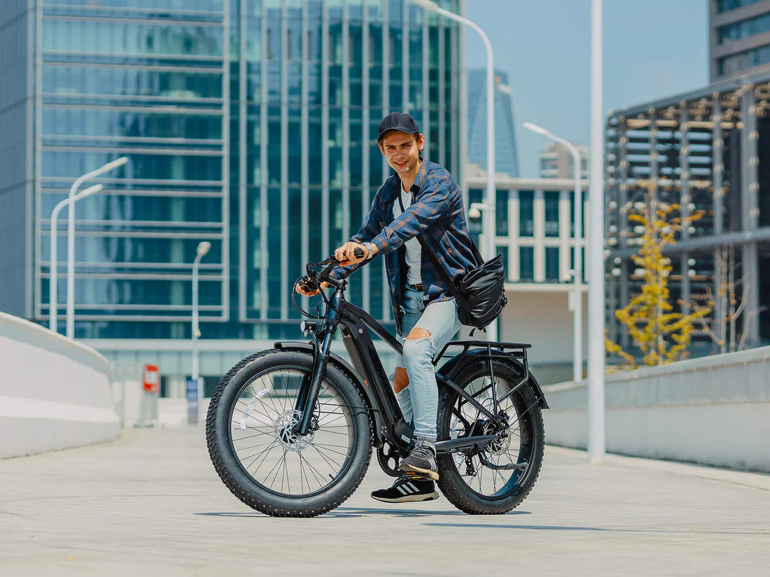Velowave Ranger 3.0 Fat Tire All-Terrain Electric Bike Man riding an electric bike in an urban setting with modern buildings in the background. Valowave Ranger 3.0 Fat Tire All-Terrain Electric Bike