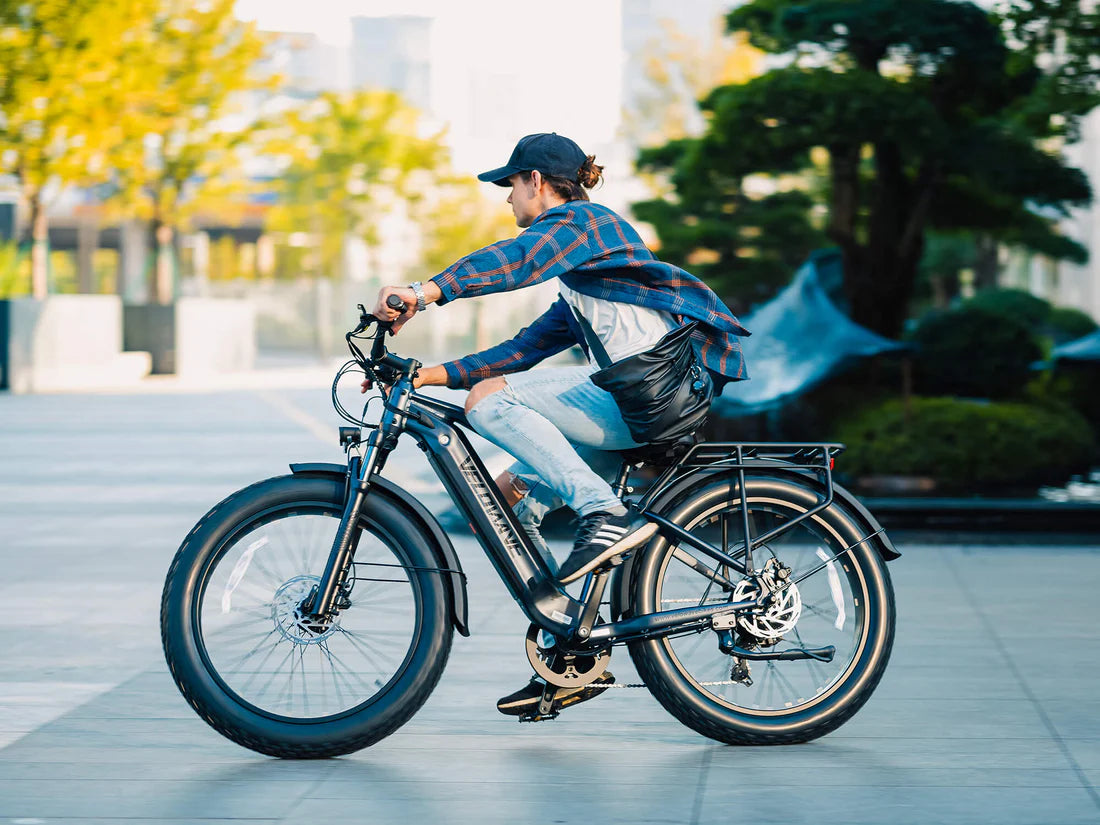 Velowave Ranger 3.0 Fat Tire All-Terrain Electric Bike Person riding an electric bike in an urban setting with trees and buildings in the background. Valowave Ranger 3.0 Fat Tire All-Terrain Electric Bike