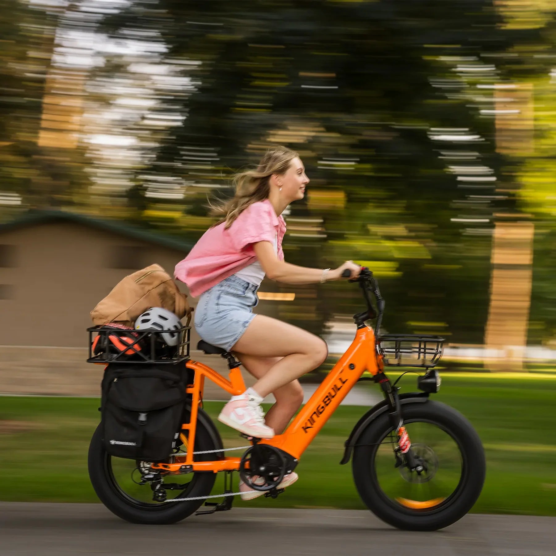 Kingbull Voyager 2.0 Fat Tire Electric Cargo Bike Woman riding an orange electric bike with a blurred background. Kingbull Voyager 2.0 Fat Tire Electric Cargo Bike