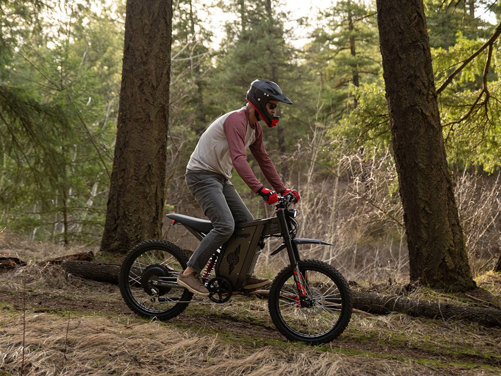 Freego X2 Pro All-Terrain Dirt eBike Person riding an electric bike through a forest. Freego X2 Pro All-Terrain Dirt eBike
