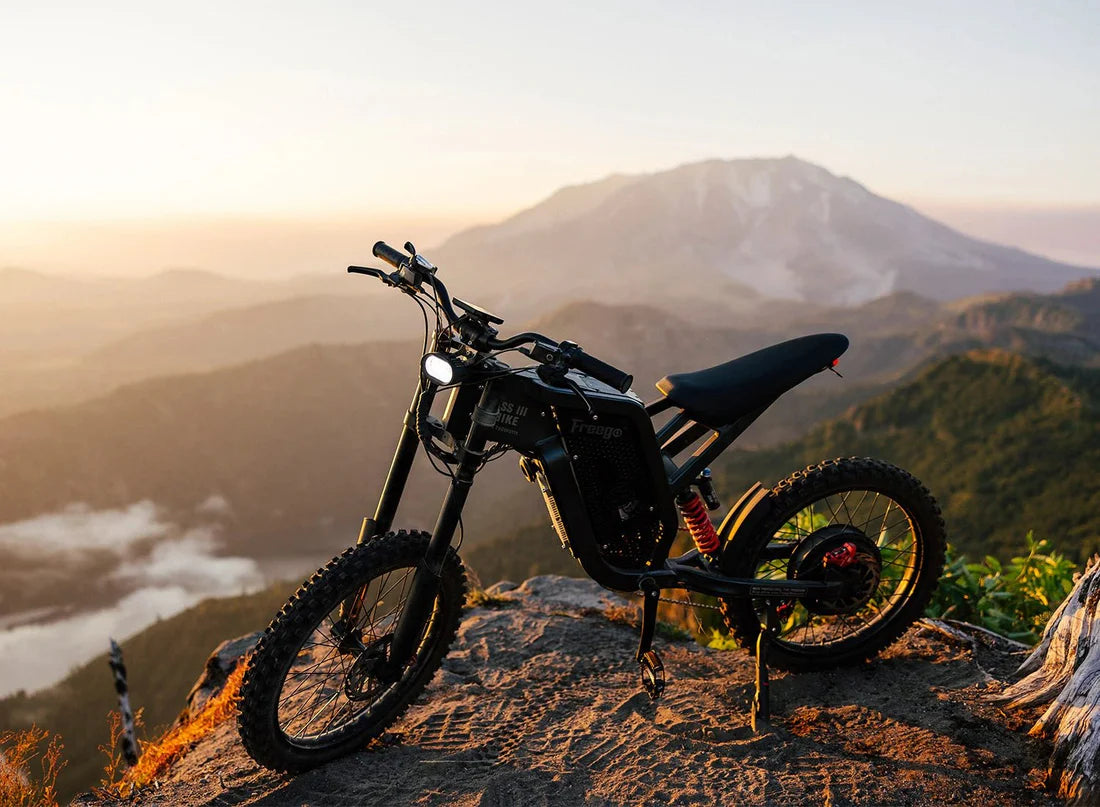 Freego X2 Dirt Master Off-Road eBike Motorcycle on a mountain top with a scenic view of mountains and water. Freego X2 Pro All-Terrain Dirt eBike