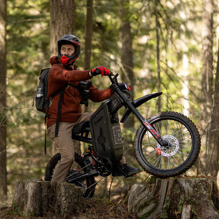 Freego X2 Pro All-Terrain Dirt eBike Person with a motorized bike in a forest setting. Freego X2 Pro All-Terrain Dirt eBike