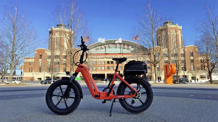 YOUNG Electric E-Flow 750W Folding eBike Red electric bike on a city street with buildings in the background. YOUNG Electric E-Flow 750W Folding eBike