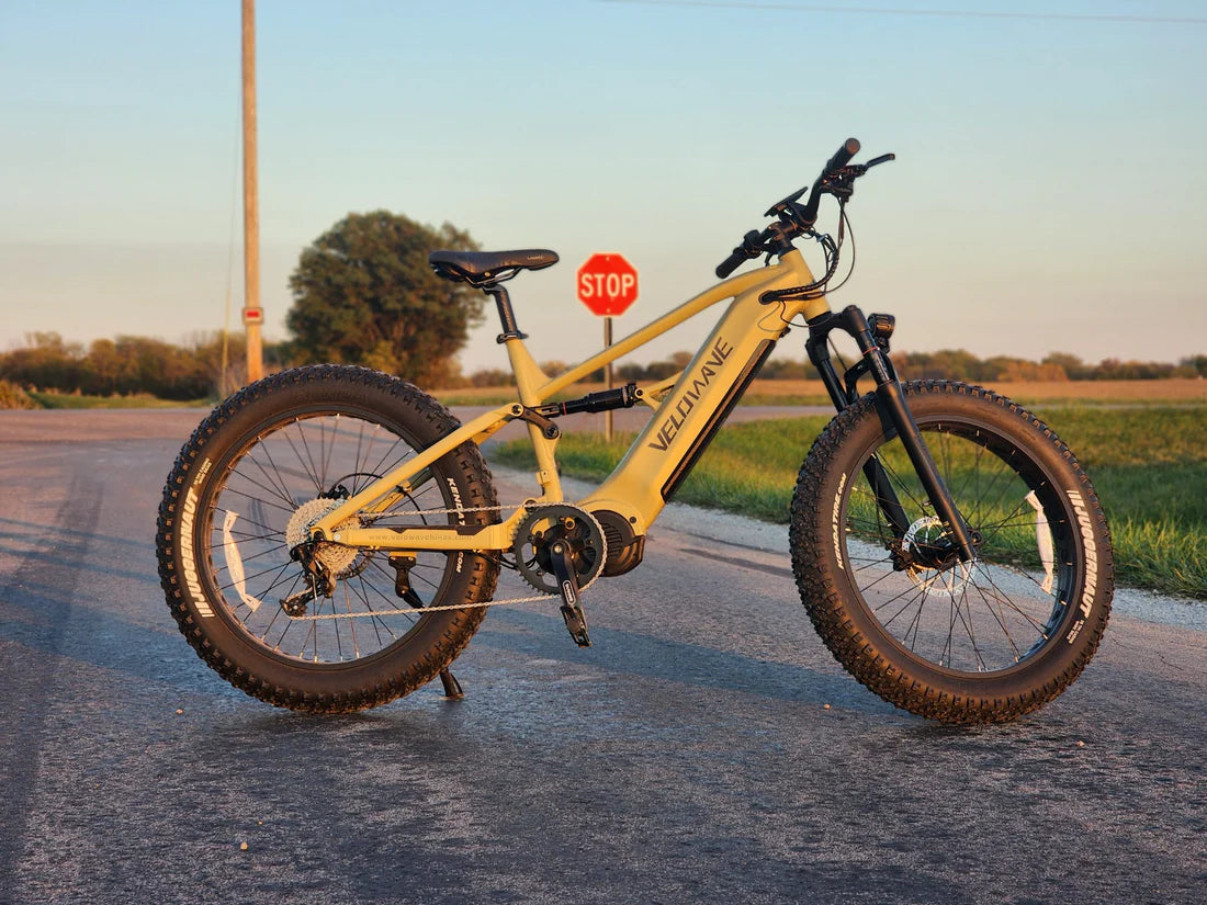 Velowave Brawny XM MTB Mountain Electric Bike Yellow electric bike on a road with a stop sign in the background. Valowave Brawny XM MTB Mountain Electric Bike