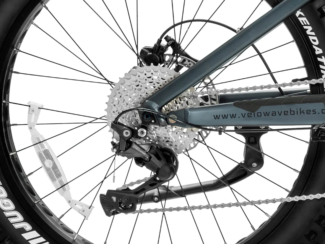Velowave Brawny XM MTB Mountain Electric Bike Close-up of a bicycle chain and gear system with 'Velowave Bikes' branding. Valowave Brawny XM MTB Mountain Electric Bike