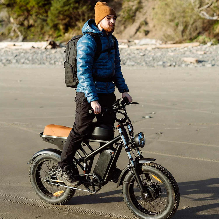Freego Flash F3 Pro Max Dual Motor and Battery eBike Man riding an electric bike on a beach with a backpack. Freego Flash F3 Pro Max Dual Motor and Battery eBike