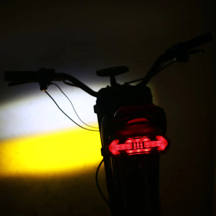 Freego Nova 2 Mid-Drive Youth Electric Dirt Bike Bicycle tail light emitting a red glow in a dark setting. Freego Nova 2 Mid-Drive Youth Electric Dirt Bike