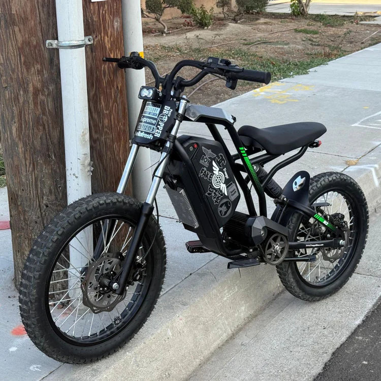 Freego Nova 3 Mid-Drive All-Terrain Dirt eBike Black electric bike parked on a sidewalk next to a wooden post. Freego Nova 3 Mid-Drive All-Terrain Dirt eBike