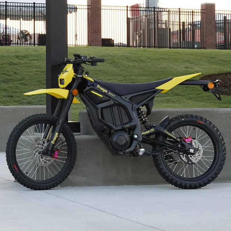 Freego Nova 5 Mid-Drive Off-Road Electric Dirt Bike Yellow and black electric bike on a concrete surface with grass and a fence in the background. Freego Nova 5 Mid-Drive Off-Road Electric Dirt Bike