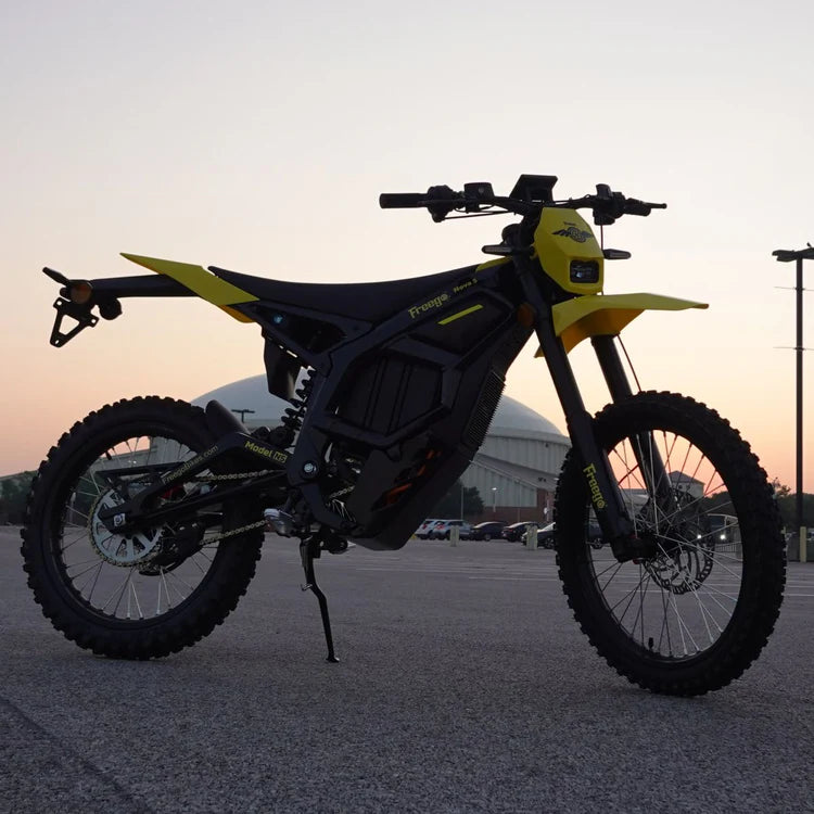 Freego Nova 5 Mid-Drive Off-Road Electric Dirt Bike Yellow and black dirt bike on a paved surface with a sunset or sunrise background. Freego Nova 5 Mid-Drive Off-Road Electric Dirt Bike