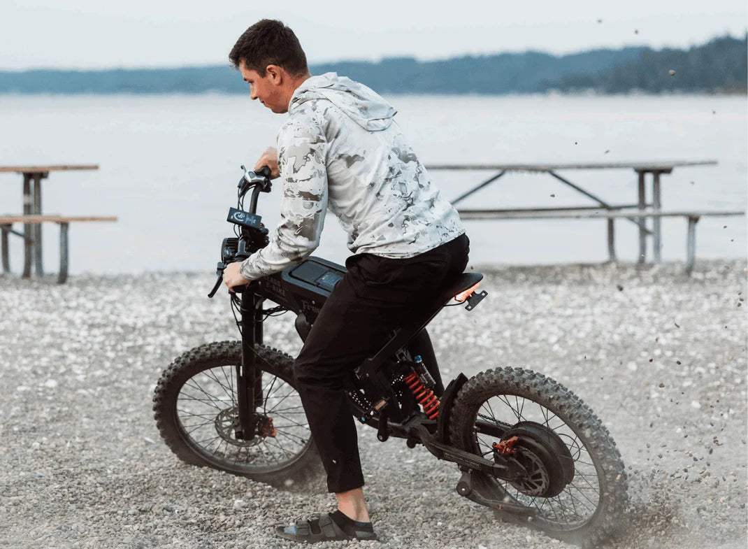 Freego X2 Dirt Master Off-Road eBike Person on a unique bicycle by a lake. Freego X2 Pro All-Terrain Dirt eBike