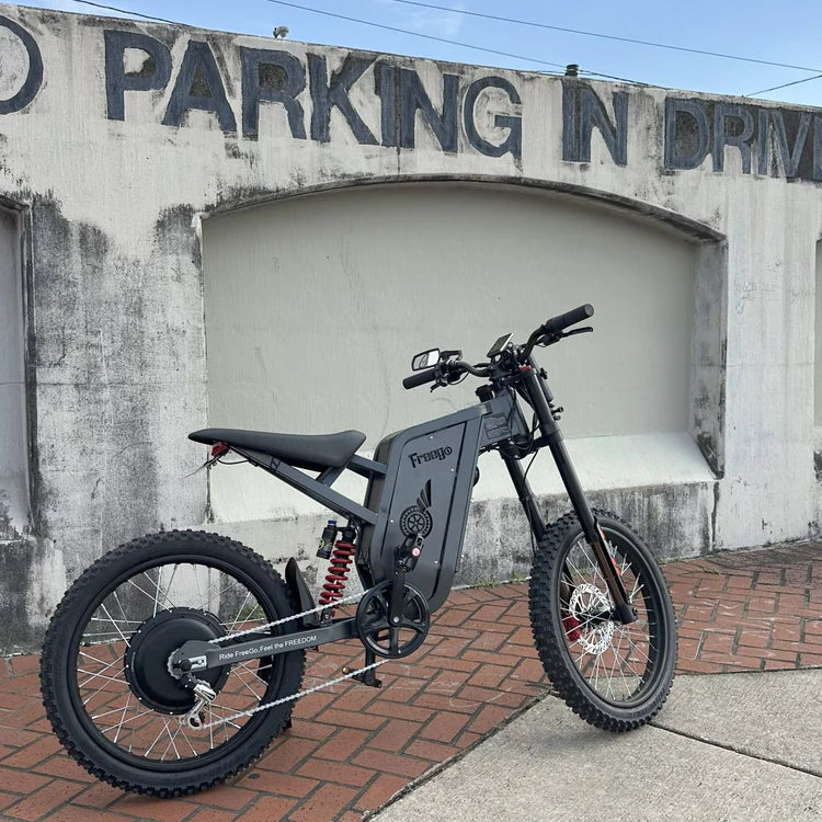 Freego X2 Pro All-Terrain Dirt eBike Black electric bike parked in front of a building with 'No Parking in Drive' . Freego X2 Pro All-Terrain Dirt eBikesign.
