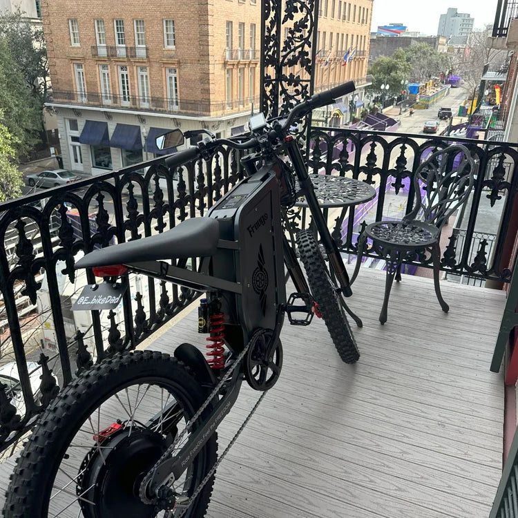 Freego X2 Pro All-Terrain Dirt eBike Electric bike on a balcony with a city street view in the background. Freego X2 Pro All-Terrain Dirt eBike
