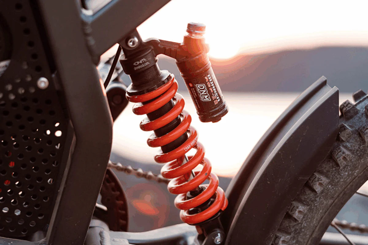 Freego X2 Dirt Master Off-Road eBike Close-up of a motorcycle suspension system with a bottle of oil against a blurred background. Freego X2 Pro All-Terrain Dirt eBike