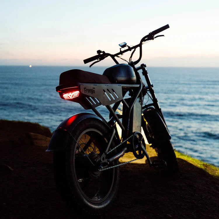 Freego Flash F3 Pro Max Dual Motor and Battery eBike Motorcycle parked by the ocean with a sunset in the background. Freego Flash F3 Pro Max Dual Motor and Battery eBike
