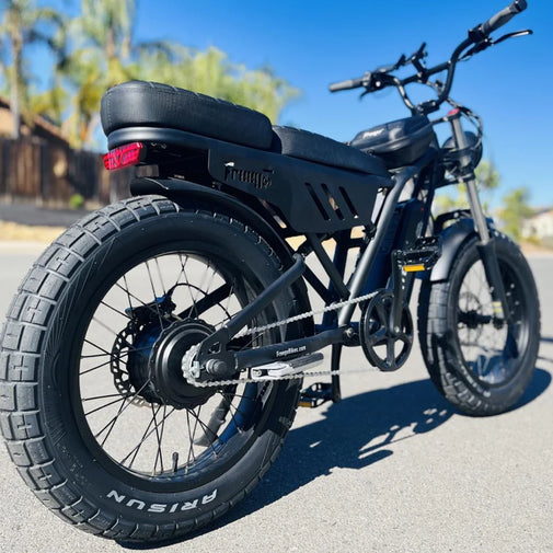 Black electric bike on a paved road with a clear blue sky. Freego Shotgun Lite F0: Ideal Electric Bike for Short Riders