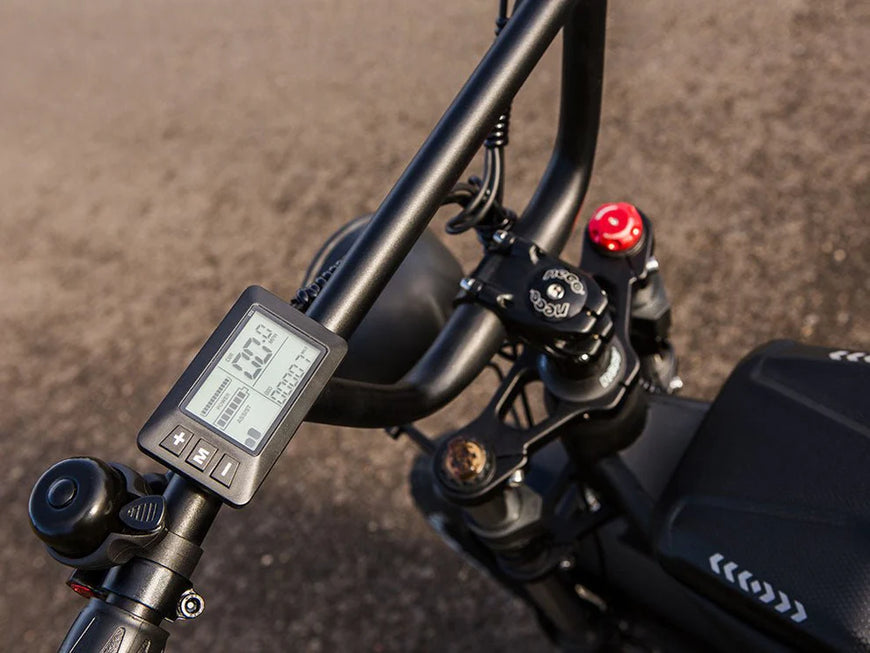 Close-up of a bicycle handlebar with digital display and brake lever on a blurred road background. Freego Shotgun Prime F2 Pro Electric Cargo Bike