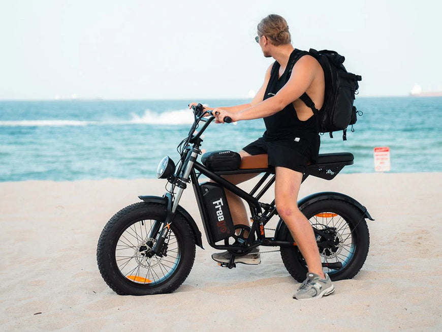 Electric bike on a sandy beach with palm trees in the background. Freego Shotgun Prime F2 Pro Electric Cargo Bike