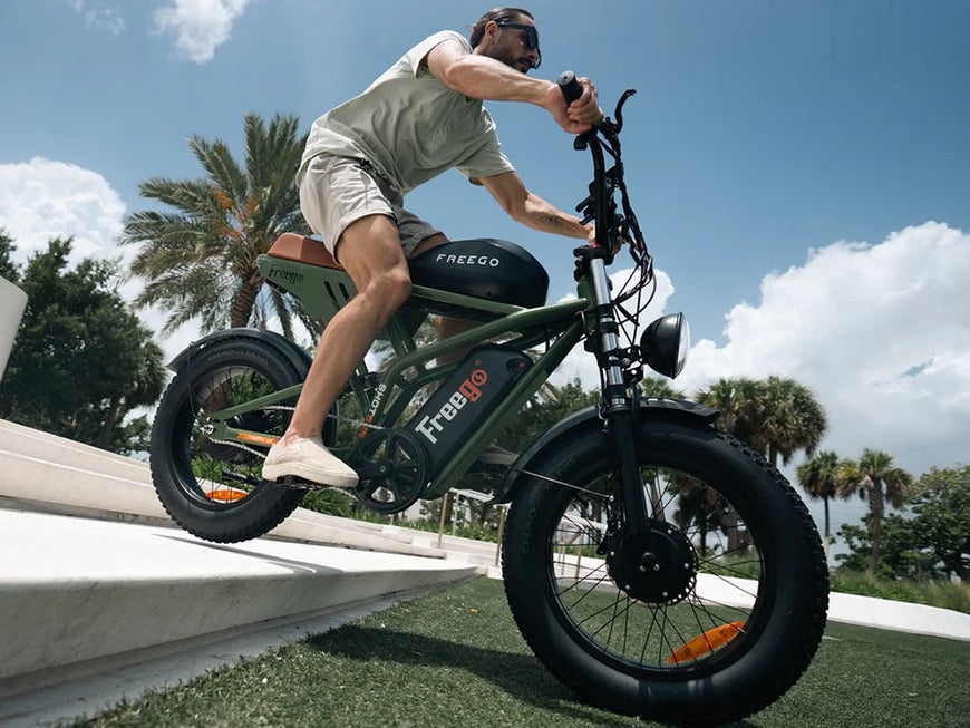 Person riding a green electric bike with large wheels on a sunny day. Freego Flash F3 Pro Dual Motor and Battery eBike
