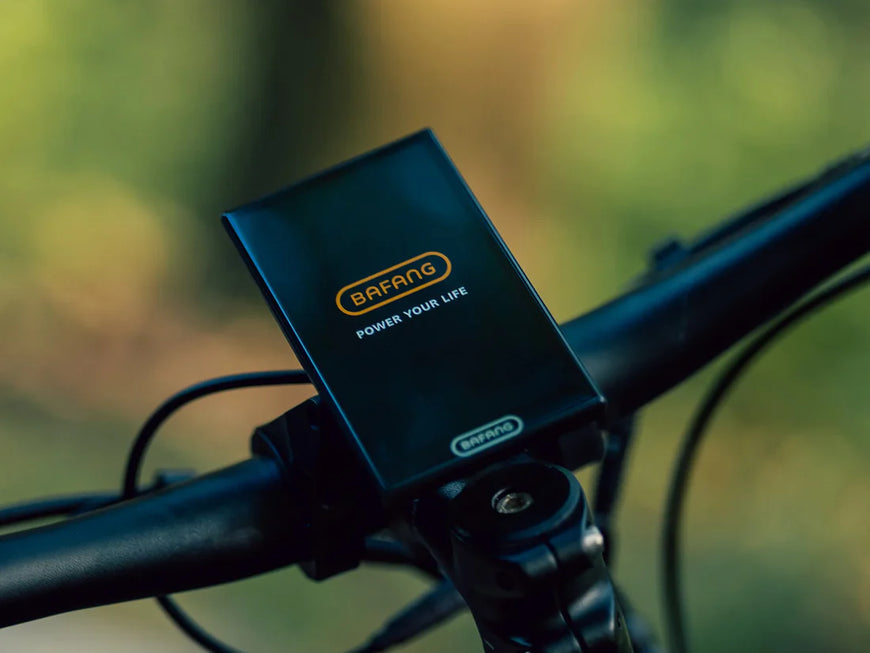 Bafang battery pack mounted on a bicycle handlebar with a blurred green background. Valowave Forest XM MTB