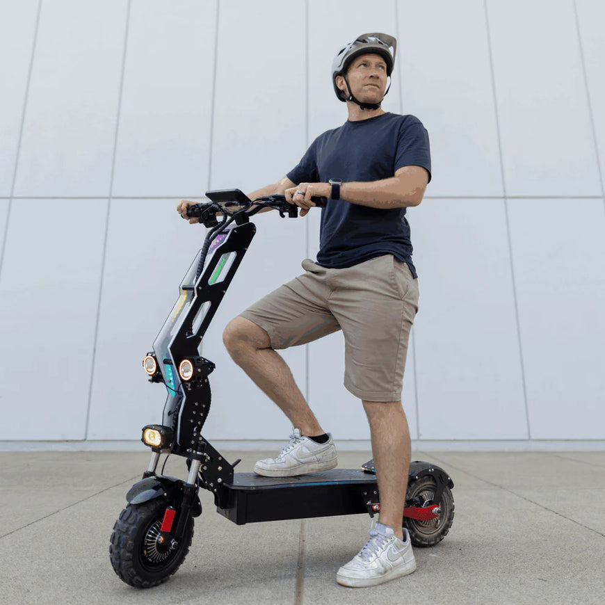 Man riding an electric scooter against a white wall. Freego D11 Landtiger Electric Scooter Foldable Dual Motor 4000W