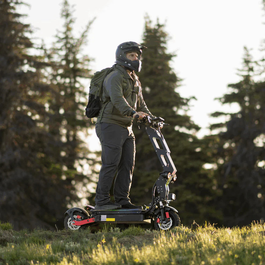 Person riding an electric scooter in a forested area. Freego D11 Landtiger Electric Scooter Foldable Dual Motor 4000W