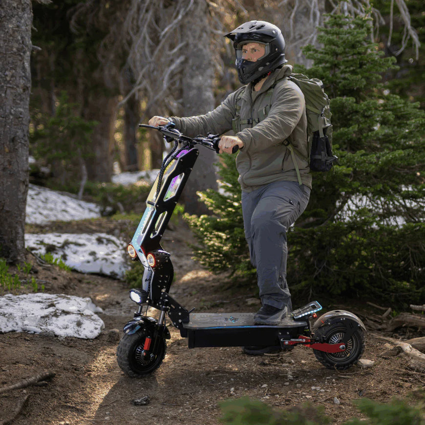 Person riding an electric scooter in a forested area. Freego D11 Landtiger Electric Scooter Foldable Dual Motor 4000W