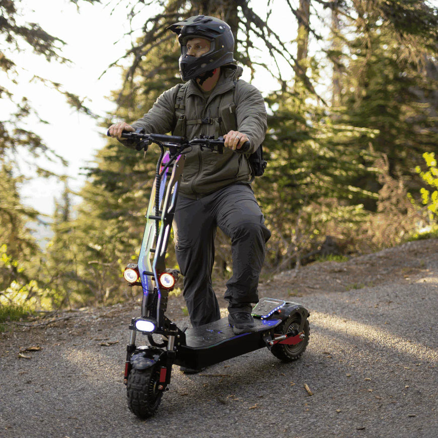 Person riding an electric scooter on a forest path. Freego D11 Landtiger Electric Scooter Foldable Dual Motor 4000W