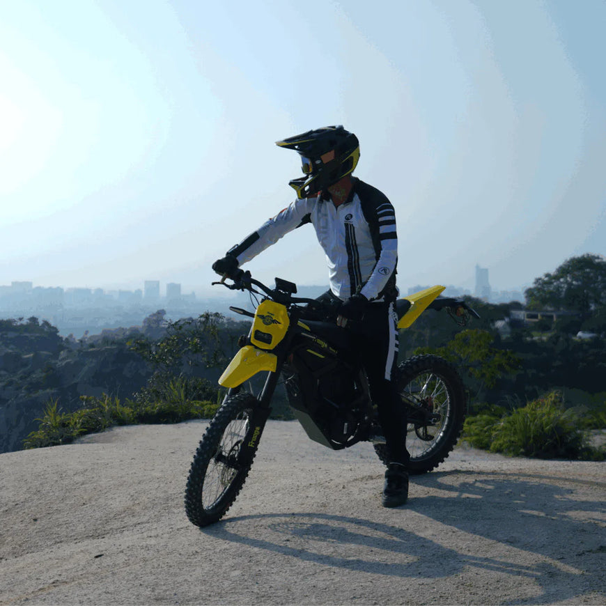 Person on a yellow motorcycle with a cityscape in the background. Freego Nova 5 Mid-Drive Off-Road Electric Dirt Bike