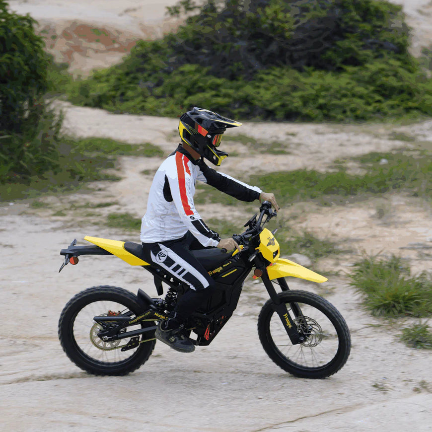 Person riding a yellow motorcycle on a dirt path with greenery in the background. Freego Nova 5 Mid-Drive Off-Road Electric Dirt Bike