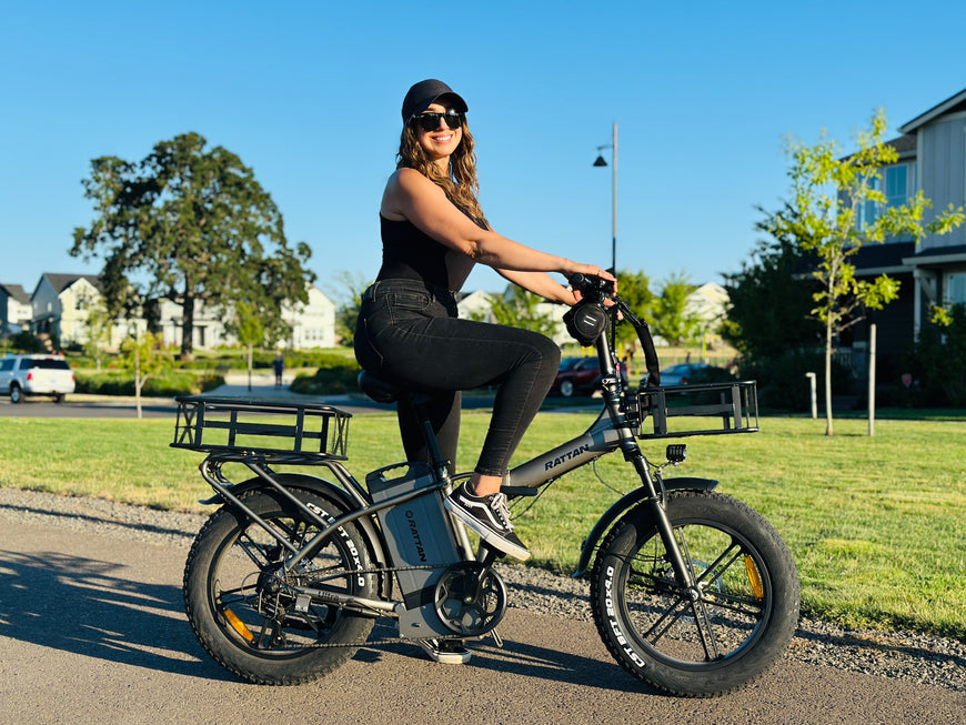 Woman riding a electric bike on a sunny day in a residential area. Rattan LM Ultra Folding ebike