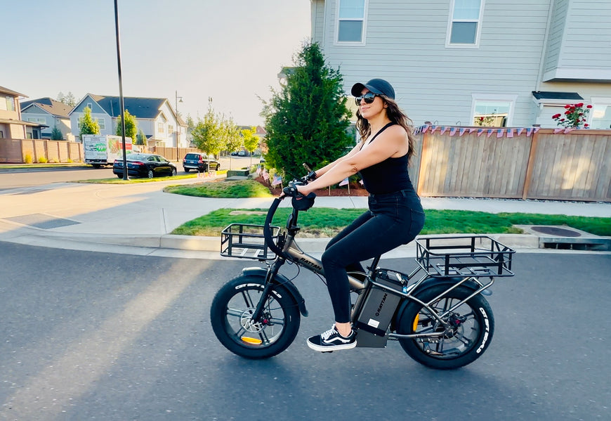 Woman riding a cargo bike with a basket on a residential street. Rattan LM Ultra Folding ebike