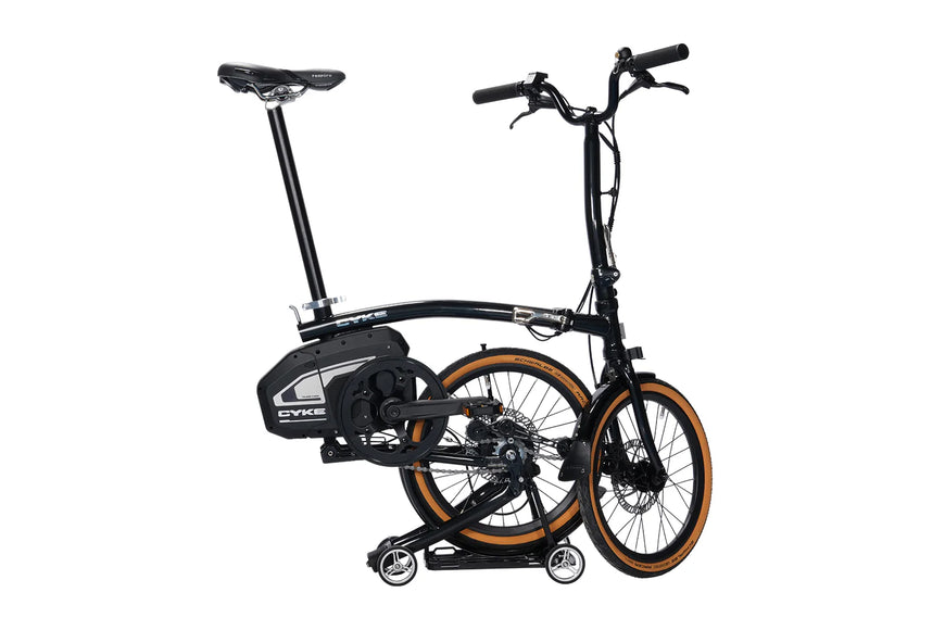 Black folding bike with orange rims on a white background. CYKE Kingfisher Mid-Drive Folding eBike