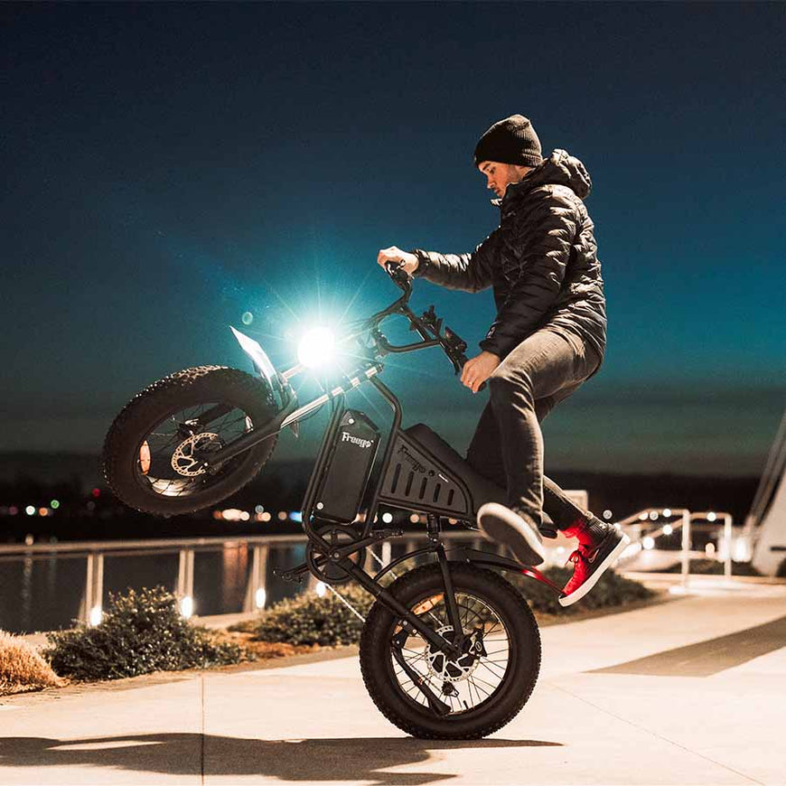Person performing a wheelie on a electric bike at night. Freego S1 Cafe Racer eBike