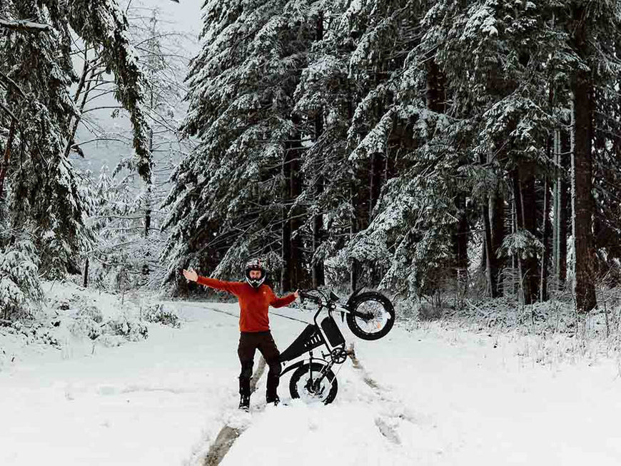 Person with a snow bike in a snowy forest. Freego S1 Cafe Racer eBike
