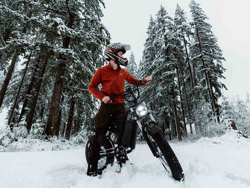 Person on a snow bike in a snowy forest. Freego S1 Cafe Racer eBike