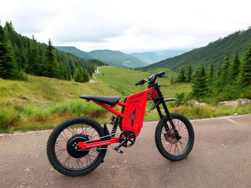 Red electric bike on a road with a scenic mountain landscape. Freego X2 Pro All-Terrain Dirt eBike