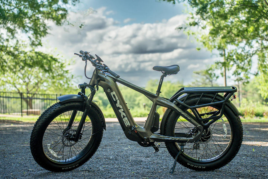 Electric bike on a gravel path with trees and sky in the background. CYKE Cheetah Hunting EBike