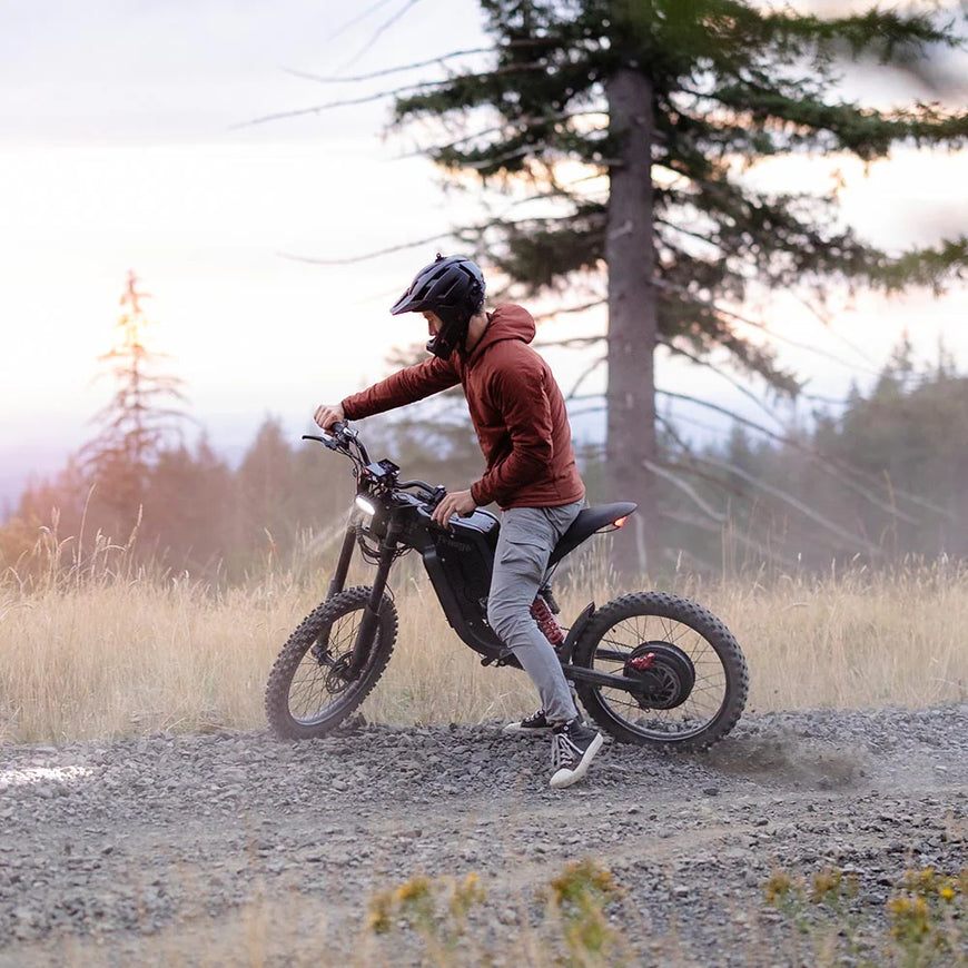 Person riding a electric bike on a dirt path with trees in the background. Freego X2 Pro All-Terrain Dirt eBike