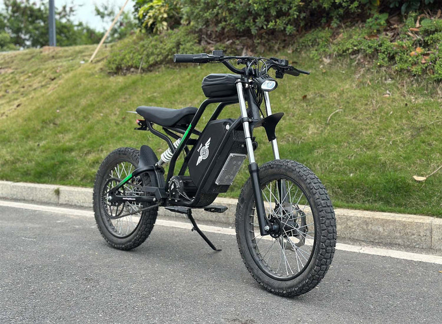 Black electric bike on a road with grass and trees in the background. Freego Nova 3 Mid-Drive All-Terrain Dirt eBike